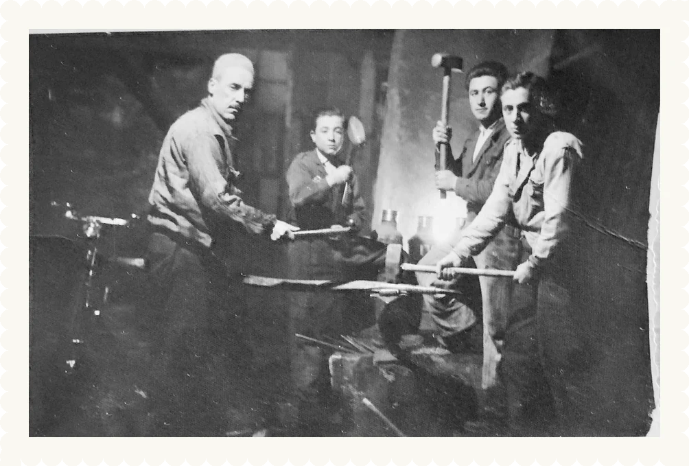 Demirci atölyesinde dört usta, örsün başında. Aile arşivi.